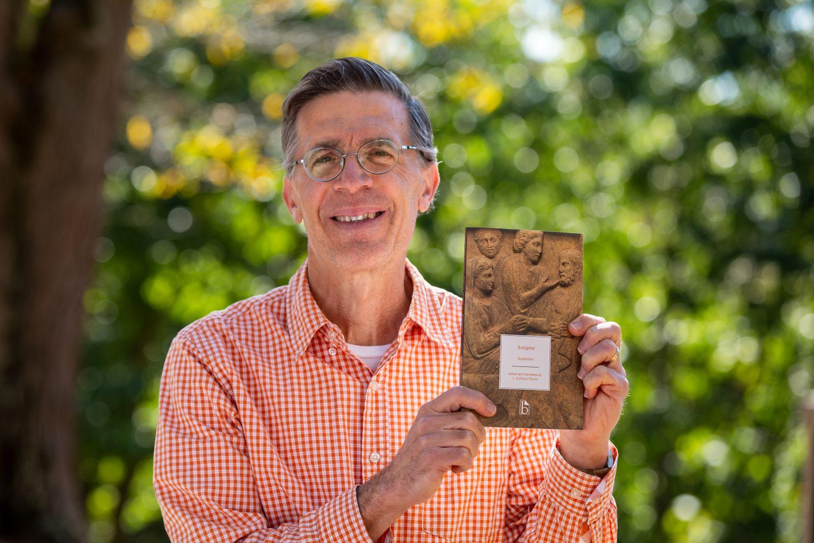 Dr. J. Aultman-Moore poses by Eberly Library with his published translation