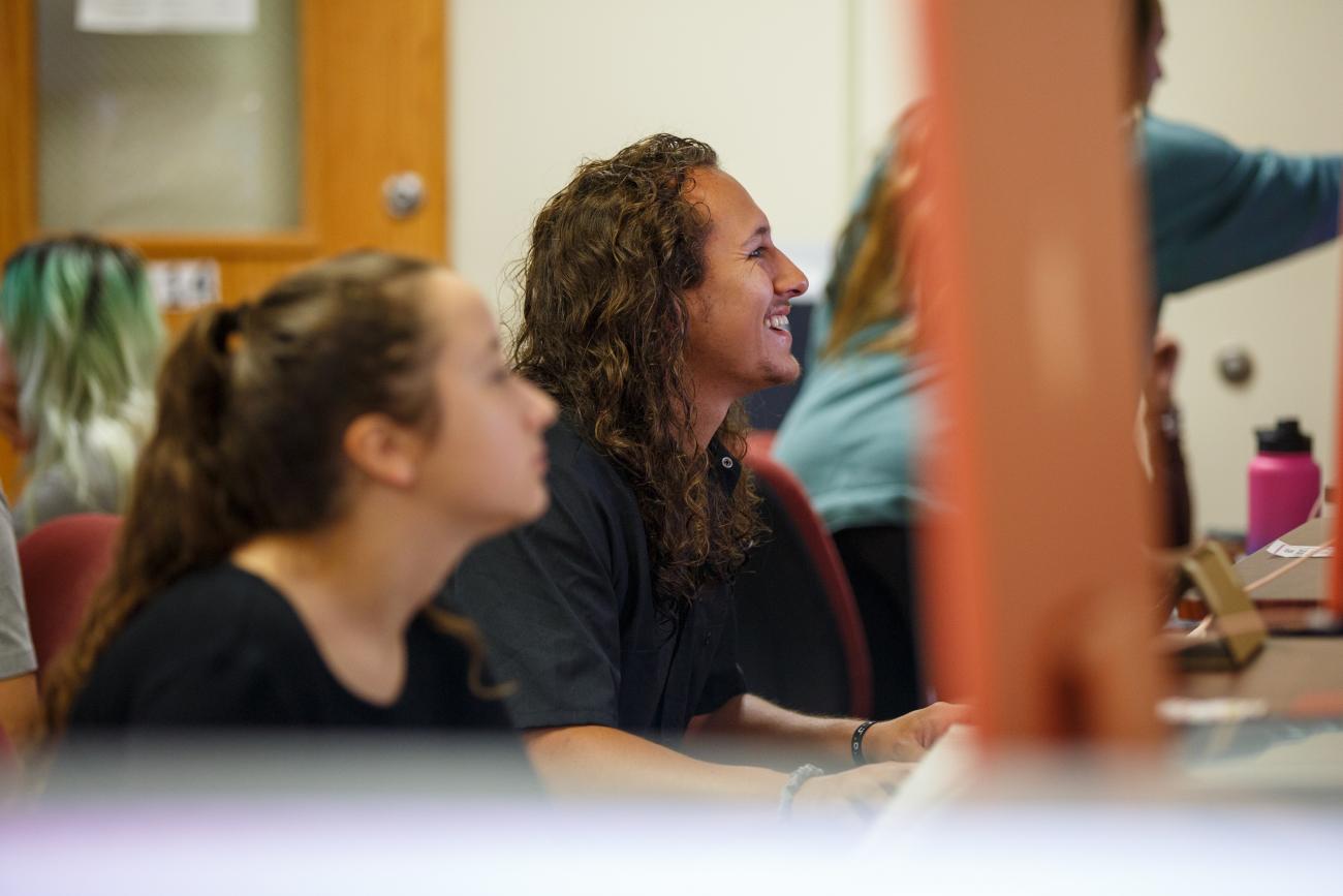 student smiling at computer 