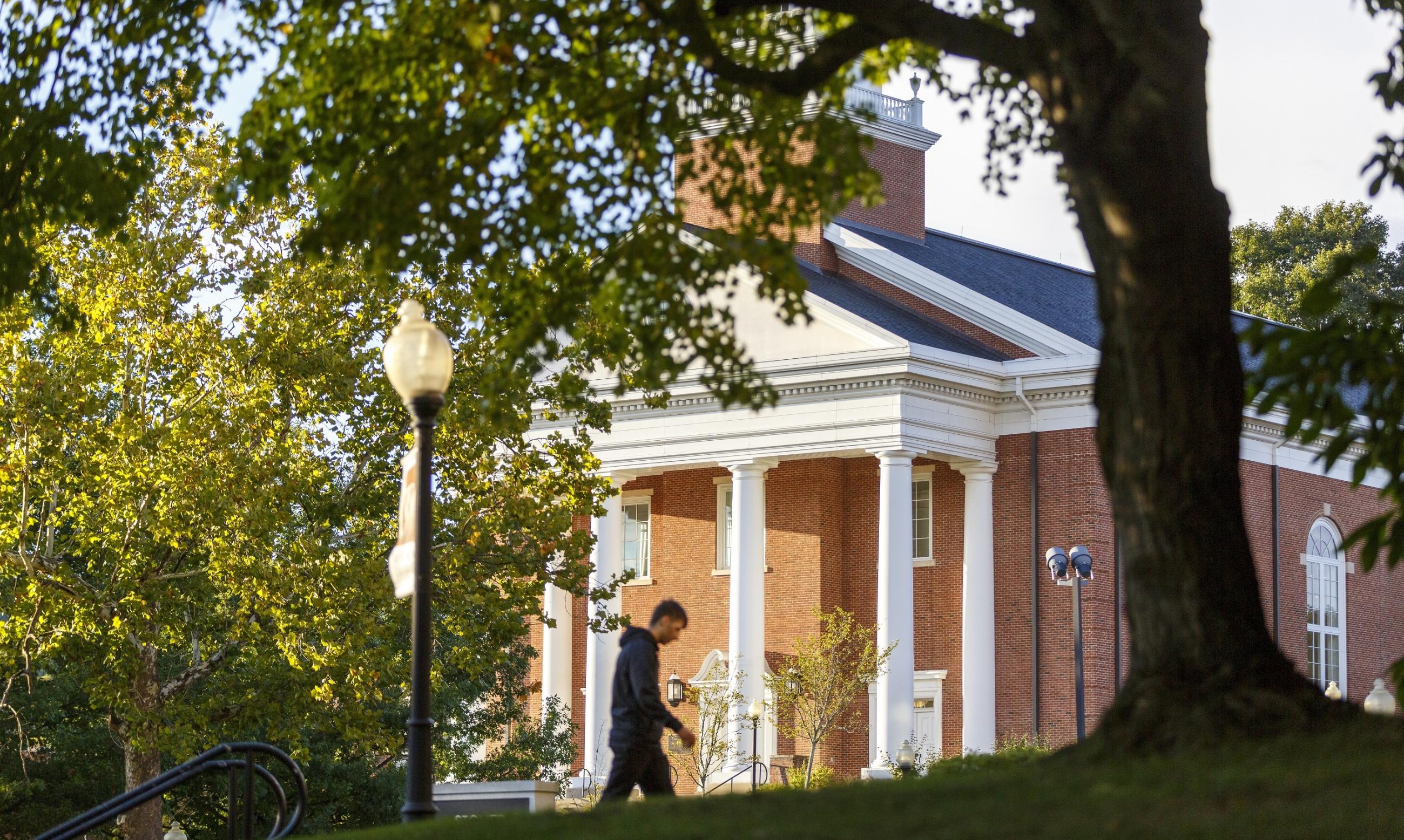 solitary student walks in front of chapel on Waynesburg University's campus
