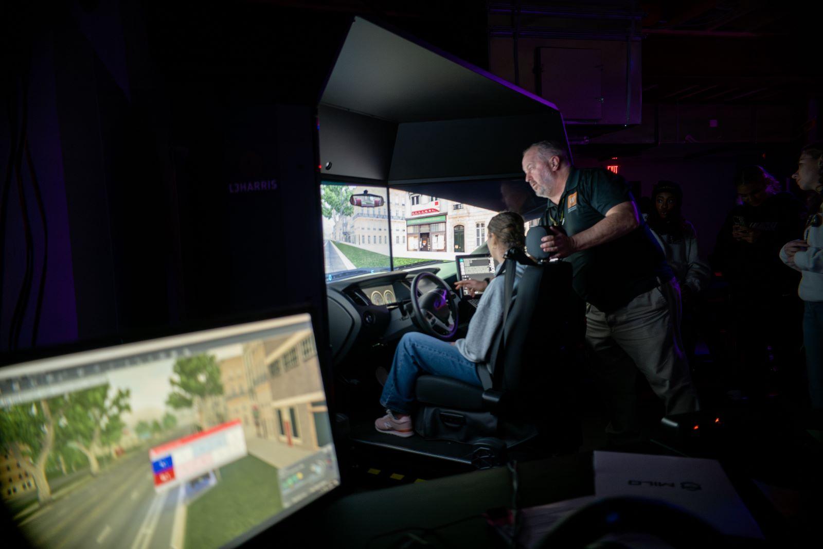 Professor Cairns instructs a student on the L3 Harris driving simulator