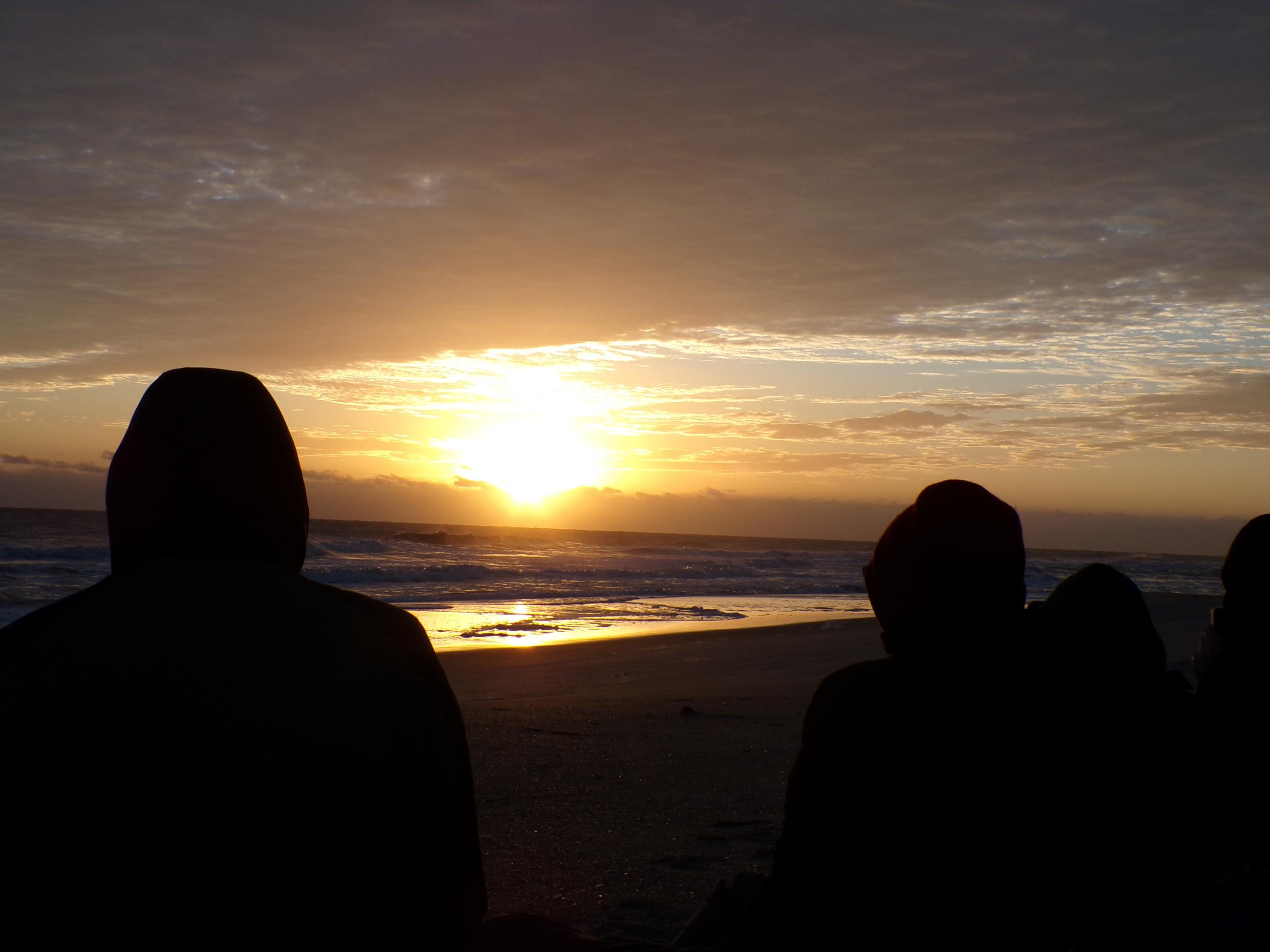 The setting sun shines across the ocean in a blaze of yellow