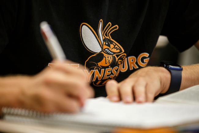 Student takes notes in the classroom at Waynesburg U