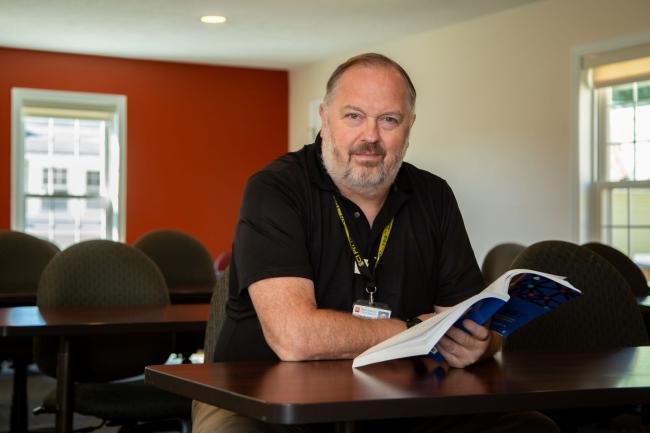 Dr. Kenneth Cairns poses with his published textbook